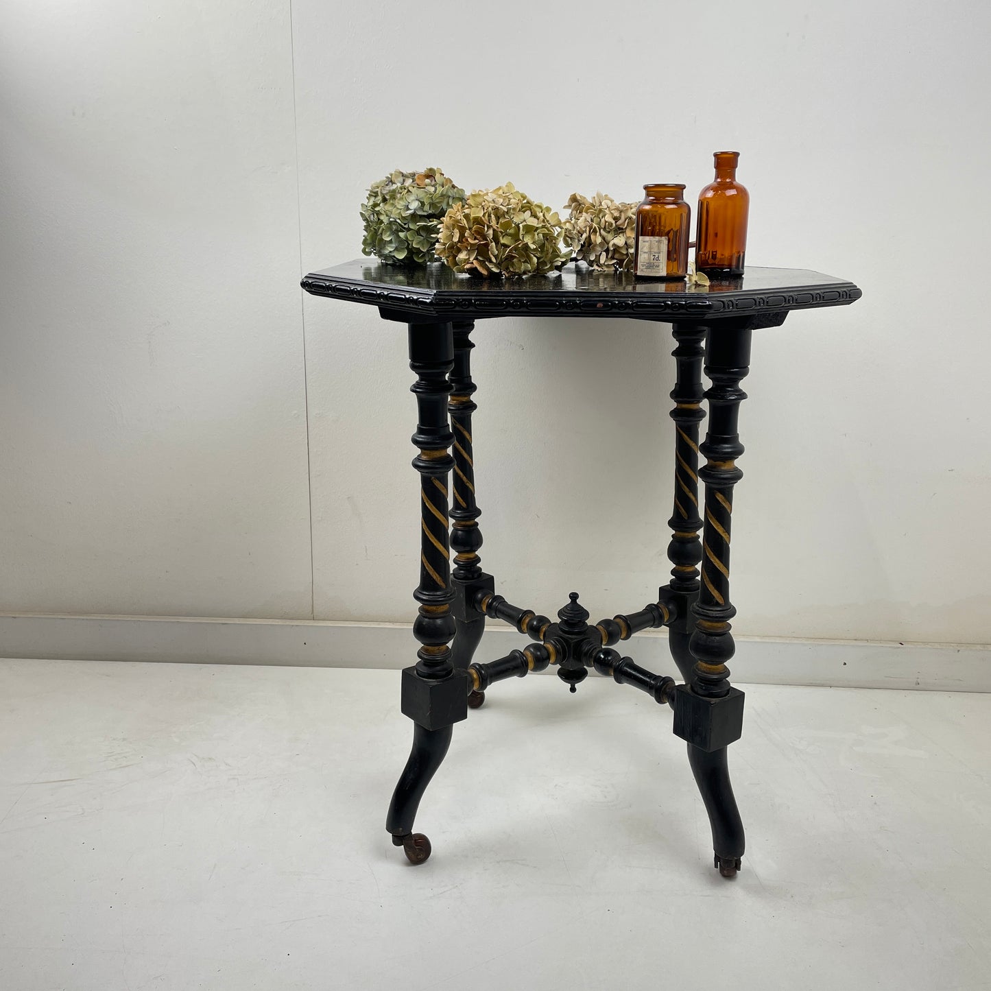EBONISED SIDE TABLE ON CASTORS