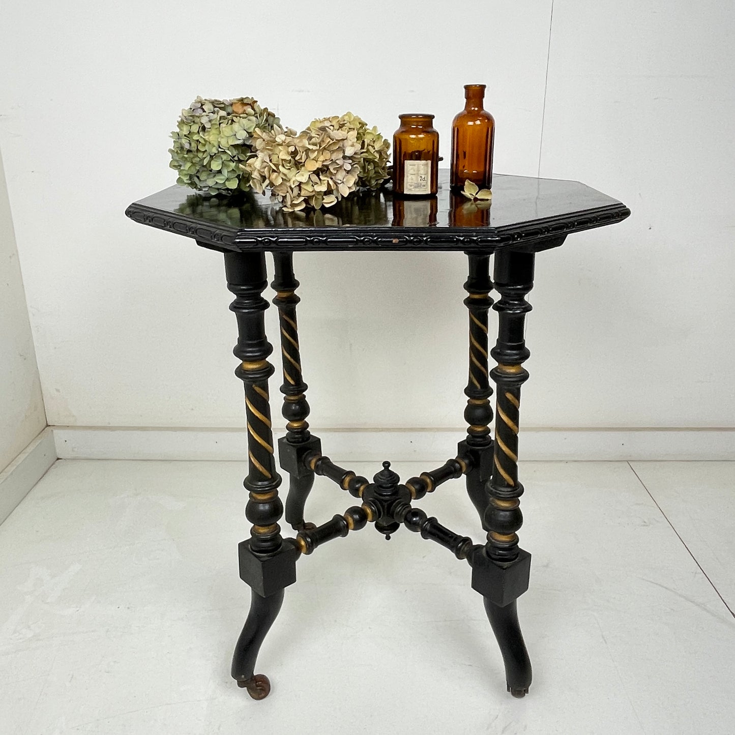 EBONISED SIDE TABLE ON CASTORS