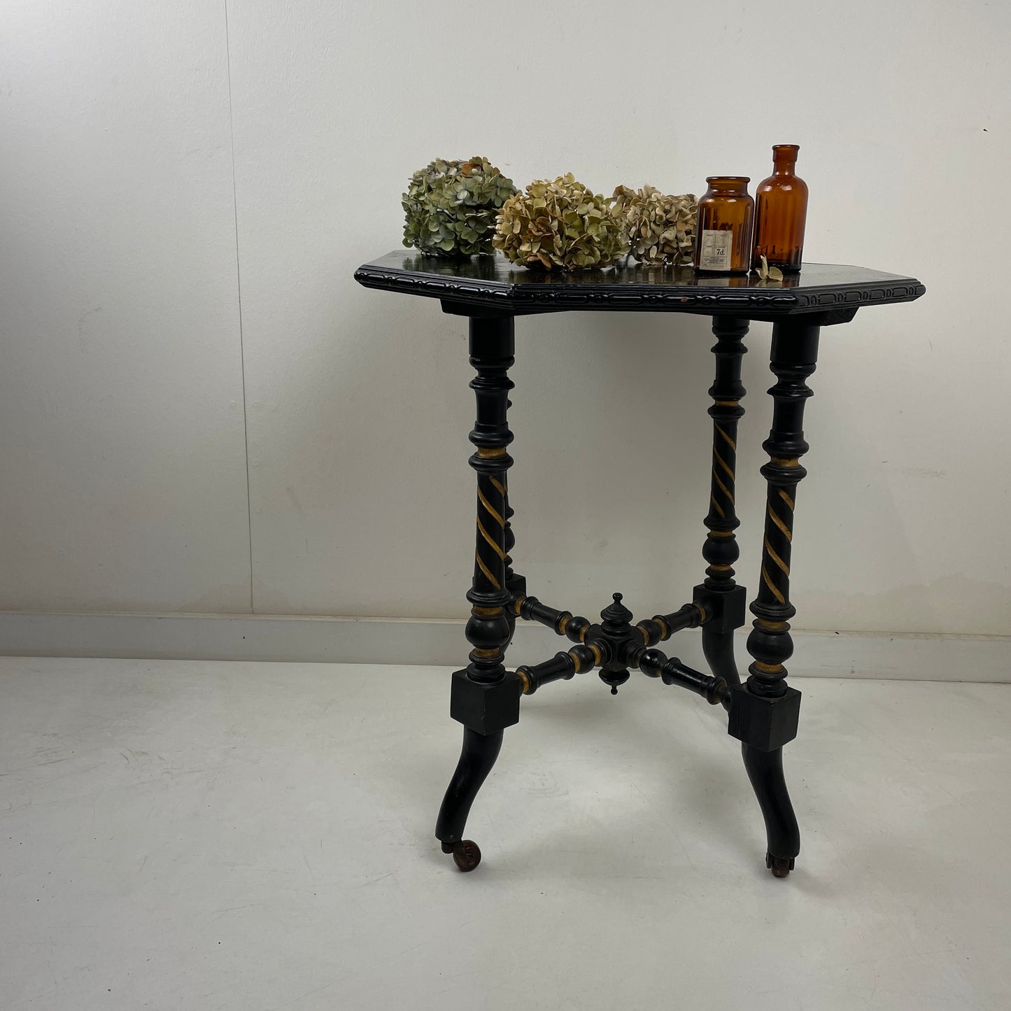 EBONISED SIDE TABLE ON CASTORS