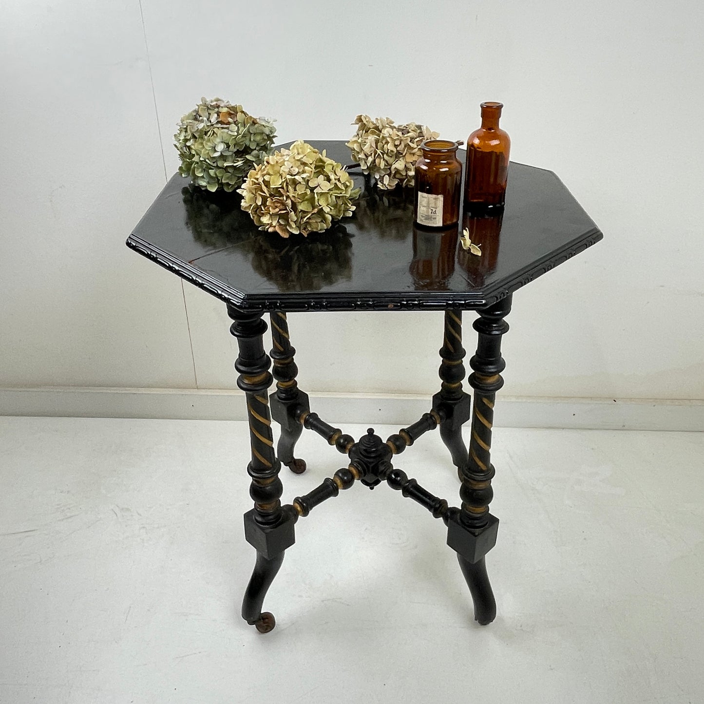 EBONISED SIDE TABLE ON CASTORS