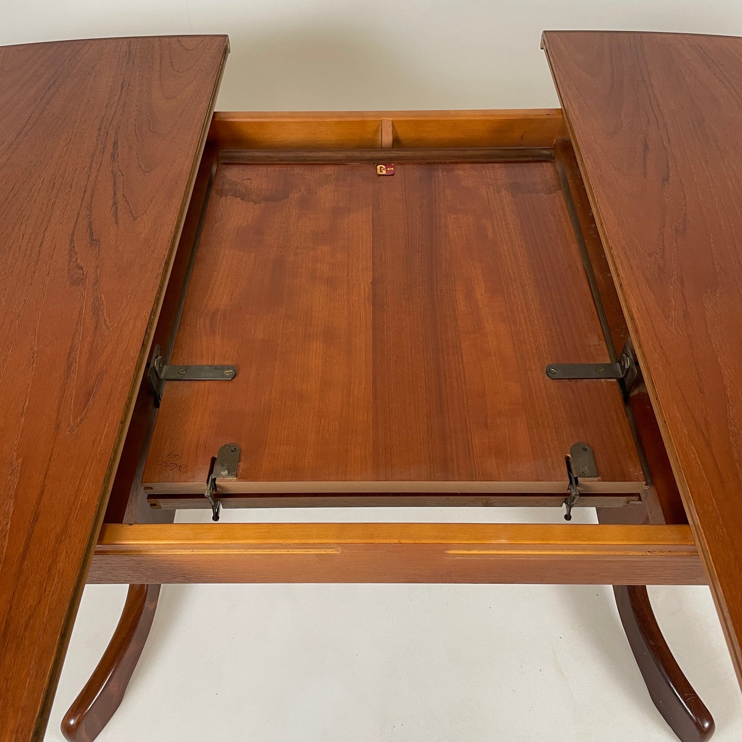 the middle extending part of the midcentury gplan table is photographed, it has clean metl connectors to pull the table connection out and make it into a larger table to seat more guests securely. 